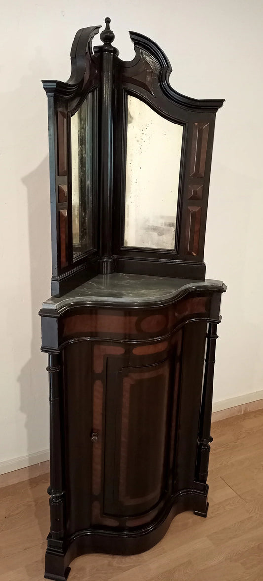Magnífico mueble esquinero en excelente estado con tapa de espejo y cuerpo inferior curvo de madera oscura.
