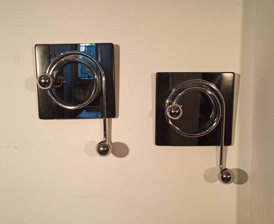 Par de elegantes percheros de pared negros con ganchos metálicos curvados, diseñados por Willy Rizzo en la década de 1970.