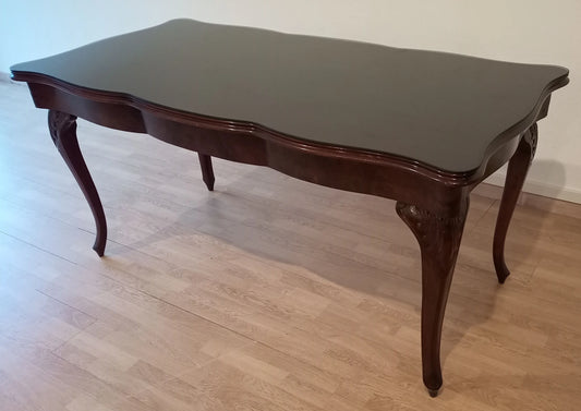 Preciosa mesa Chippendale vintage de cristal templado ahumado con patas curvas y bordes festoneados en madera oscura.