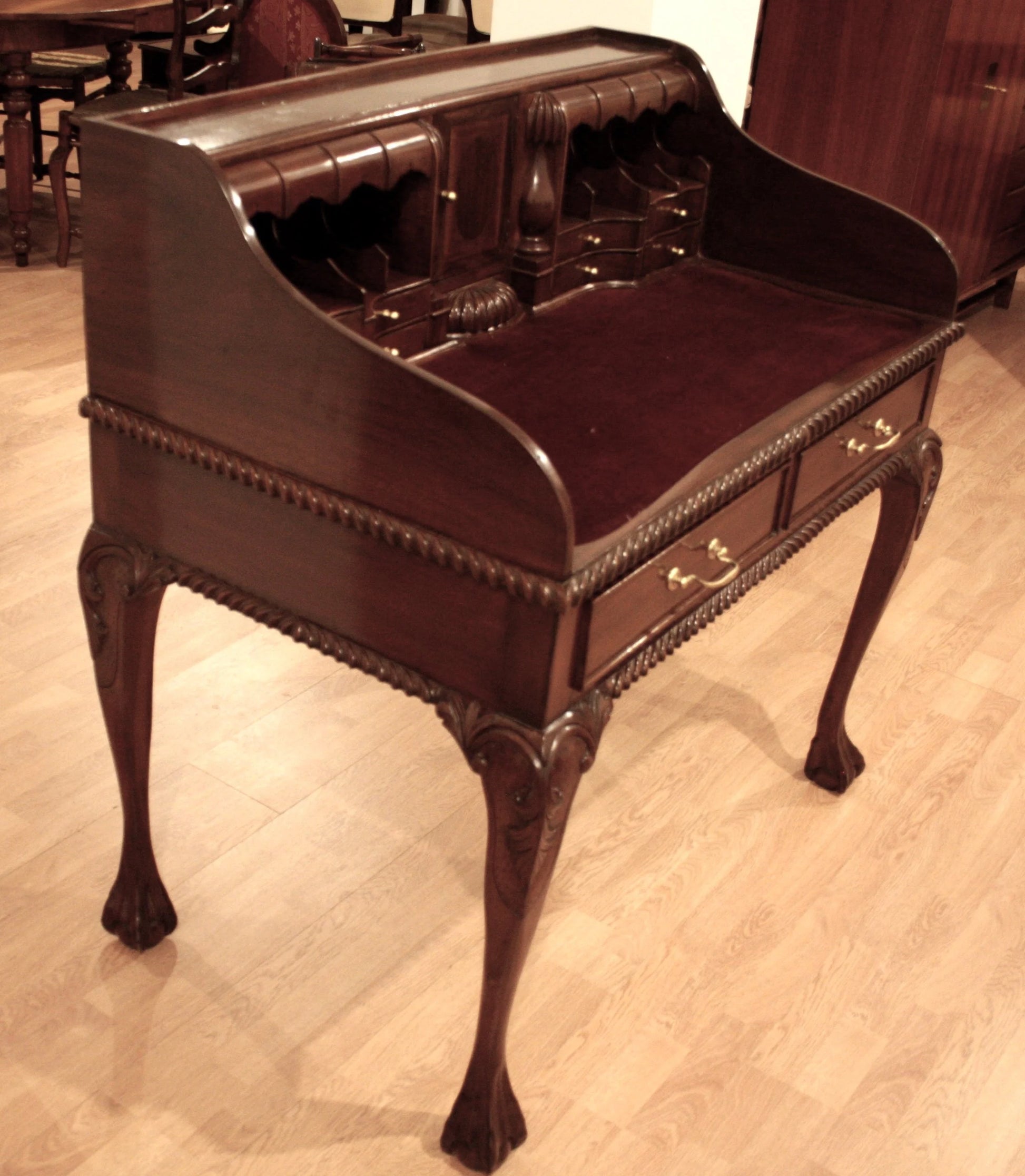 Escritorio de oficina de nogal estilo Chippendale inglés ornamentado con patas arqueadas y detalles decorativos.