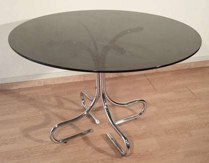 Tavolino da caffè con base curva in acciaio cromato e piano rotondo in vetro fumé design italiano